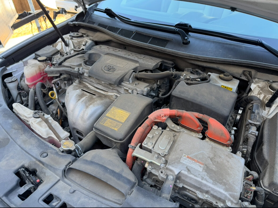 Engine bay before detailing, heavy dust and grime